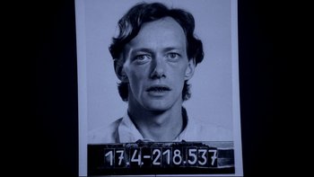 Movie still from “Angst” (1983), directed by Gerald Kargl – A black and white photo of a man's mugshot; Close Up shot, Overhead angle