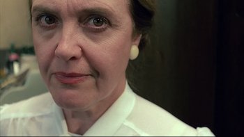 Movie still from “Angst” (1983), directed by Gerald Kargl – A person wearing a white shirt; Close Up shot, Low angle