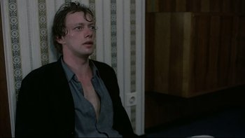 Movie still from “Angst” (1983), directed by Gerald Kargl – A man sitting in front of a wall with his eyes closed; Close Up shot, Low angle