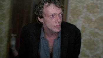 Movie still from “Angst” (1983), directed by Gerald Kargl – A person wearing a jacket; Close Up shot, Over the shoulder angle