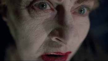 Movie still from “Angst” (1983), directed by Gerald Kargl – An older woman with red lipstick looking into the camera; Extreme Close Up shot, Overhead angle