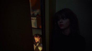 Movie still from “Angst” (1983), directed by Gerald Kargl – A woman looking out of a kitchen window at a man; Medium shot, Low angle