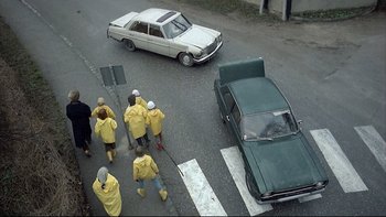 Movie still from “Angst” (1983), directed by Gerald Kargl – A group of people walking down a street; Wide shot, High angle