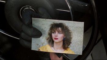 Movie still from “Angst” (1983), directed by Gerald Kargl – A hand holding a picture of a woman in a yellow shirt; Extreme Close Up shot, Overhead angle