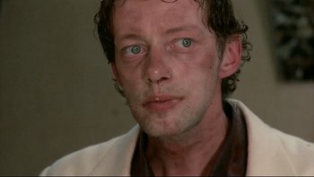 Movie still from “Angst” (1983), directed by Gerald Kargl – A person wearing a white jacket; Close Up shot, Low angle