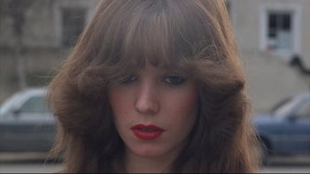 Movie still from “Angst” (1983), directed by Gerald Kargl – A person with long brown hair; Close Up shot, Low angle