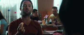 Movie still from “Animal Kingdom” (2010), directed by David Michôd – A group of people sitting at a table in a room; Close Up shot, Over the shoulder angle