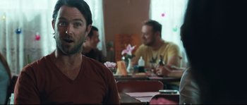 Movie still from “Animal Kingdom” (2010), directed by David Michôd – A man sitting at a table in front of two other men; Close Up shot, Over the shoulder angle