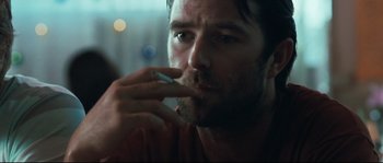 Movie still from “Animal Kingdom” (2010), directed by David Michôd – A person taking a cigarette out of his mouth; Close Up shot, Over the shoulder angle