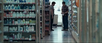 Movie still from “Animal Kingdom” (2010), directed by David Michôd – Two men are standing in a store looking at products on the floor; Wide shot, Over the shoulder angle