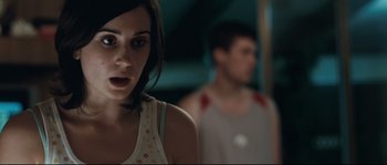 Movie still from “Animal Kingdom” (2010), directed by David Michôd – A woman standing next to a man in a room; Close Up shot, Over the shoulder angle