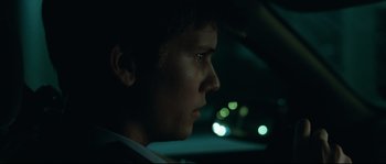 Movie still from “Animal Kingdom” (2010), directed by David Michôd – A young man is sitting in the driver's seat of a car at night; Close Up shot, Over the shoulder angle
