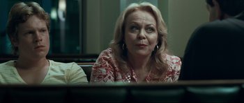Movie still from “Animal Kingdom” (2010), directed by David Michôd – A person sitting at a table; Close Up shot, Over the shoulder angle