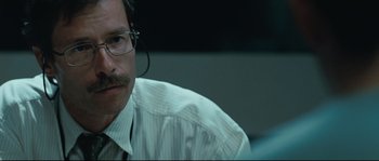 Movie still from “Animal Kingdom” (2010), directed by David Michôd – A man with a headset on sitting in front of a computer screen; Close Up shot, Over the shoulder angle