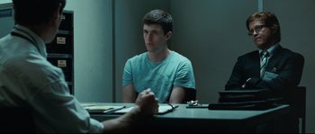 Movie still from “Animal Kingdom” (2010), directed by David Michôd – A man sitting in front of another man in front of a table; Medium shot, Over the shoulder angle