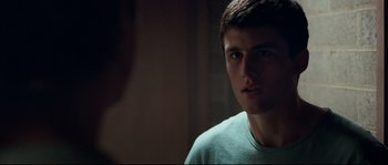 Movie still from “Animal Kingdom” (2010), directed by David Michôd – A young man is looking at the camera in a dark room; Close Up shot, Over the shoulder angle