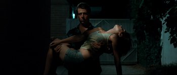 Movie still from “Animal Kingdom” (2010), directed by David Michôd – A man holding a woman while she lies on the ground; Medium shot, Low angle