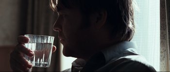 Movie still from “Animal Kingdom” (2010), directed by David Michôd – A person holding a glass of water; Close Up shot, Over the shoulder angle