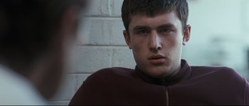 Movie still from “Animal Kingdom” (2010), directed by David Michôd – A person wearing a maroon jacket; Close Up shot, Low angle