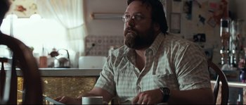 Movie still from “Animal Kingdom” (2010), directed by David Michôd – A man sitting at a table drinking a cup of coffee; Close Up shot, Over the shoulder angle