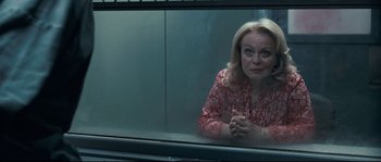 Movie still from “Animal Kingdom” (2010), directed by David Michôd – A woman sitting on a window sill looking out of a window; Medium shot, Over the shoulder angle