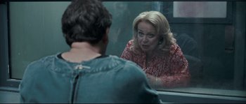 An older woman looking at a younger man in a mirror