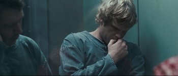 Movie still from “Animal Kingdom” (2010), directed by David Michôd – A man with his hand to his face and his chin resting on his hands; Close Up shot, Over the shoulder angle