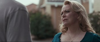 Movie still from “Animal Kingdom” (2010), directed by David Michôd – An older woman is standing in front of a building; Close Up shot, Over the shoulder angle