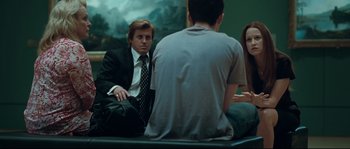 Movie still from “Animal Kingdom” (2010), directed by David Michôd – A group of people sitting in a room talking to each other; Medium shot, Over the shoulder angle