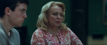 Movie still from “Animal Kingdom” (2010), directed by David Michôd – A woman with blonde hair wearing a red and white shirt; Close Up shot, Over the shoulder angle