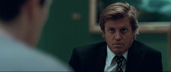 Movie still from “Animal Kingdom” (2010), directed by David Michôd – A person wearing a suit and tie; Close Up shot, Over the shoulder angle