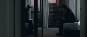Movie still from “Animal Kingdom” (2010), directed by David Michôd – A man sitting on a chair in front of a window; Wide shot, Over the shoulder angle