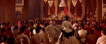 Movie still from “Anna and the King” (1999), directed by Andy Tennant – A group of people dressed in period clothing in front of an audience; Extreme Wide shot, High angle