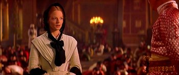 Movie still from “Anna and the King” (1999), directed by Andy Tennant – A woman wearing a white dress and a black bow tie; Medium shot, Low angle