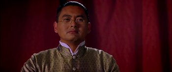 Movie still from “Anna and the King” (1999), directed by Andy Tennant – A person wearing a suit and glasses; Close Up shot, Low angle