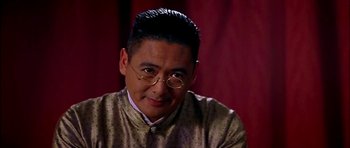 Movie still from “Anna and the King” (1999), directed by Andy Tennant – A person wearing a suit and glasses; Close Up shot, Over the shoulder angle