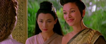 Movie still from “Anna and the King” (1999), directed by Andy Tennant – Two asian women standing next to each other in front of trees; Close Up shot, Over the shoulder angle