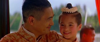 Movie still from “Anna and the King” (1999), directed by Andy Tennant – A man and a little girl smiling for the camera; Close Up shot, Over the shoulder angle