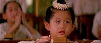 Movie still from “Anna and the King” (1999), directed by Andy Tennant – A little boy wearing a headband and looking at the camera; Close Up shot, Over the shoulder angle