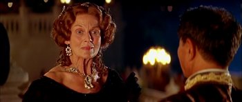 Movie still from “Anna and the King” (1999), directed by Andy Tennant – An older woman wearing a black dress and a gold necklace; Close Up shot, Low angle
