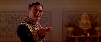 Movie still from “Anna and the King” (1999), directed by Andy Tennant – A man wearing a gold and black outfit clapping; Close Up shot, Low angle