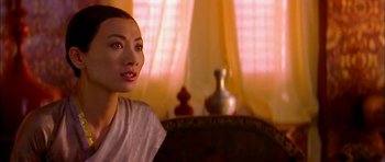 Movie still from “Anna and the King” (1999), directed by Andy Tennant – A woman sitting on a couch in a room; Close Up shot, Over the shoulder angle