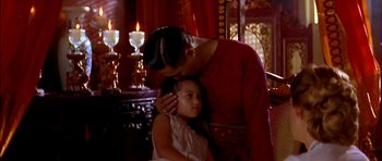 Movie still from “Anna and the King” (1999), directed by Andy Tennant – A man and a little girl standing next to each other in front of candles; Medium shot, Over the shoulder angle