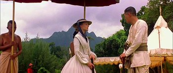 Movie still from “Anna and the King” (1999), directed by Andy Tennant – A woman in a white dress holding an umbrella; Wide shot, Over the shoulder angle