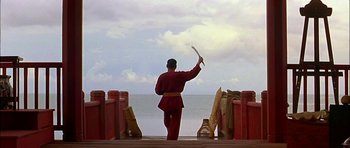 A man holding a sword on top of a wooden pier