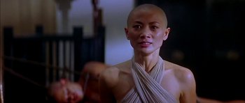 Movie still from “Anna and the King” (1999), directed by Andy Tennant – A woman with a shaved head is looking at the camera; Close Up shot, Low angle