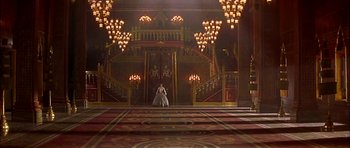 Movie still from “Anna and the King” (1999), directed by Andy Tennant – A woman dressed in a medieval dress standing in front of an ornate staircase; Extreme Wide shot, High angle