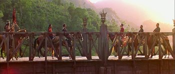 Movie still from “Anna and the King” (1999), directed by Andy Tennant – A group of people riding horses across a bridge; Extreme Wide shot, Low angle
