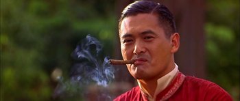 Movie still from “Anna and the King” (1999), directed by Andy Tennant – A man smoking a cigar while wearing a red shirt; Close Up shot, Low angle