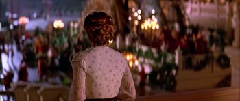 Movie still from “Anna and the King” (1999), directed by Andy Tennant – A woman in a white blouse is looking at a chandelier; Wide shot, Over the shoulder angle